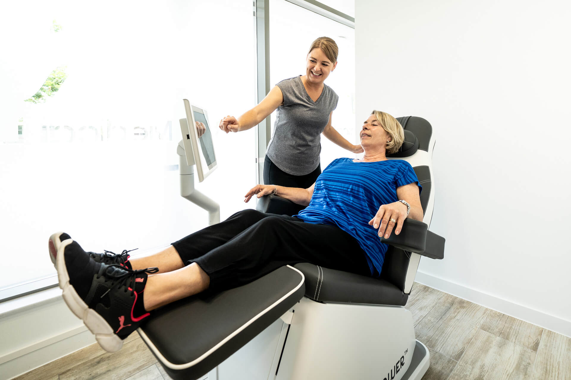 PelviPower pelvic floor training. Woman using PelviPower chair with trainer.